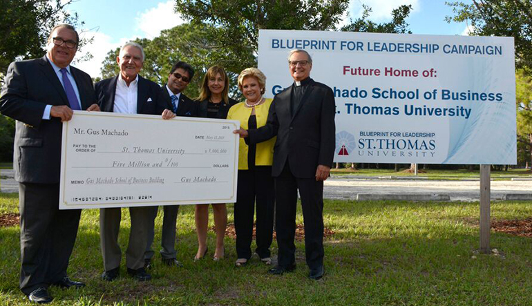 Posing with the million check where the new Gus Machado School of Business will be built, from left: John Dooner, chairman of St. Thomas University's board of trustees; Gus Machado; School of Business Dean Somnath Bhattacharya; St. Thomas Provost Irma Becerra; Lilliam Machado; and Msgr. Franklyn Casale, St. Thomas University president.