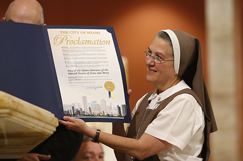 Mother Adela Galindo, foundress of the Servants of the Pierced Hearts of Jesus and Mary, holds up the proclamation from the City of Miami to mark her community's 25th anniversary.