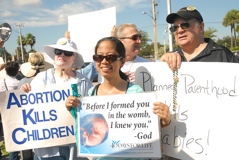 Among the protesters, at right, is Peter Crawford of St. Elizabeth Ann Seton Church in Coral Springs, who found healing through Project Rachel many years after making the decision to abort his child. “Because you will try subtle ways to kill yourself – and I've tried many – and until you face it you can't understand it. It took me about seven years to realize that I had murdered my own son and another 15 years to make a connection between why I was involved in self-destructive behavior."