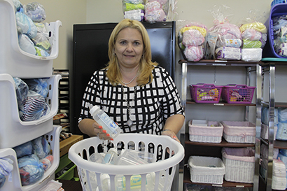 Maggie Olmedo, consejera del grupo en español, en la habitación de las donaciones, muestra los biberones que el centro envía a las parroquias durante la Campaña ‘Baby Bottle’.