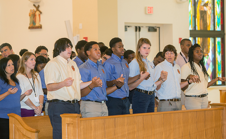Archbishop Curley Notre Dame students recite the Lord's Prayer during the Mass.