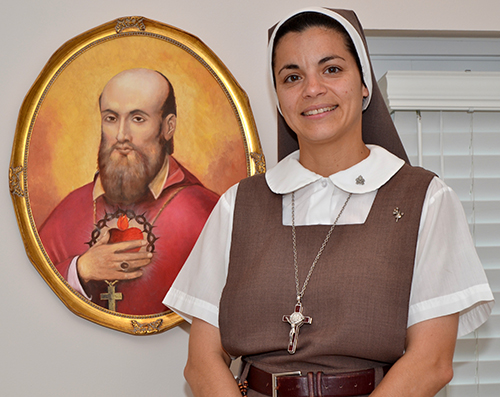 Sister Emma Rueda beside a picture of St. Francis de Sales, one of the patron saints for the Servants of the Pierced Hearts of Jesus and Mary. Sister Emma says she said her first vows on his feast day.