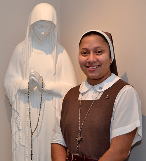 Sister Elena Castillo stands beside a favorite statue, of Our Lady of the Poor.