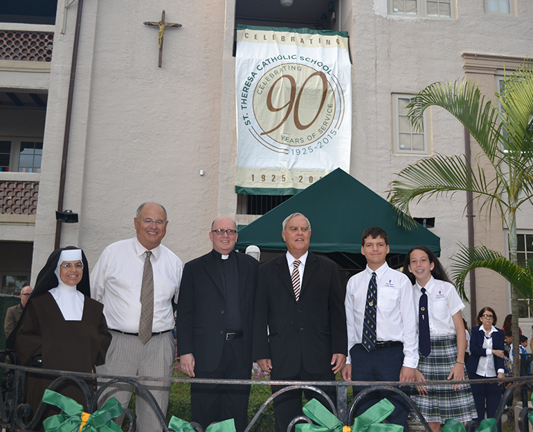 Pictured under the 90th anniversary banner, from left: Carmelite Sister Caridad Sandoval, St. Theresa School principal, Ralph Penalver, president of the Home and School Association, Little Flower's pastor, Father Michael Davis, Coral Gables Mayor Jim Cason, eighth-grader Van Hermert, student council president, and eighth-grader Julia Sariol, student council vice president.