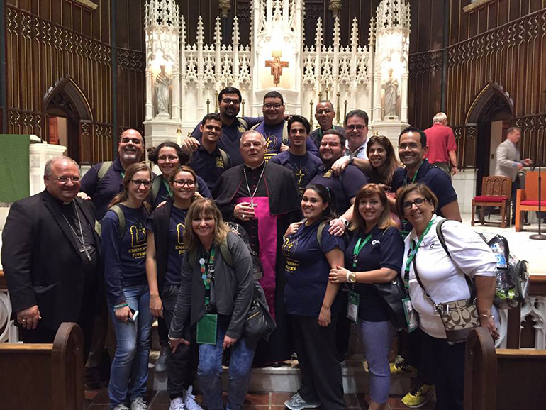 Members of Encuentros Juveniles and Camino del Matrimonio pose for a photo with Archbishop Thomas Wenski, center, and Bishop Peter Baldacchino, far left, after a Mass with all the archdiocesan pilgrims in Philadelphia's St. John the Evangelist Church.