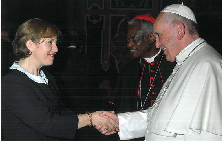 Roza Pati, law professor and director of the Human Trafficking Academy at St. Thomas University, greets Pope Francis at a meeting in Rome. Pati is the only U.S. representative at the Pontifical Council for Justice and Peace, which is headed by Cardinal Peter Turkson of Ghana, seen here behind the pope.