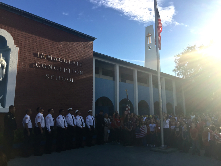 Students, faculty and staff at Immaculate Conception School in Hialeah gather for a raising of the flag with the local fire department to commemorate the attacks of Sept. 11.