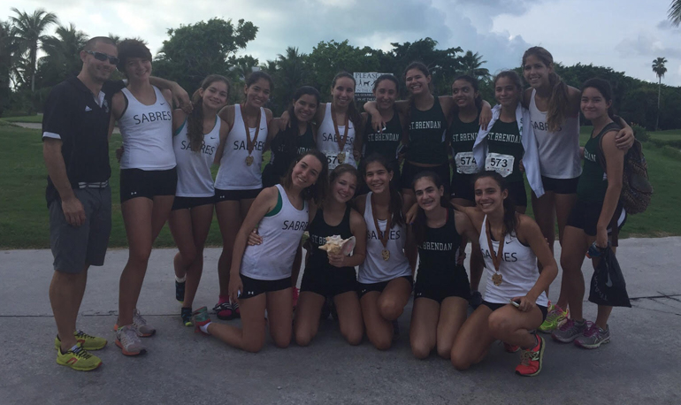 St. Brendan High's girls cross country team poses for a team shot at the Key West Excursion Invitational. In the front row (left to right) is Alejandra Moros, Carla Campos, Gabriela Gutierrez, Carolyn  Galan and Sofia Fernandez. In the top row (left to right) is Coach Carlos Maymi, Kaitlyn Miller, Julia Villena, Andrea Peterson, Cassandra Cardoso, Susana Gutierrez, Alessandra Barquin, Ana Campos, Sofia Menendez, Nicole Martinez, Lauren Lavernia and Cristina Ortega.