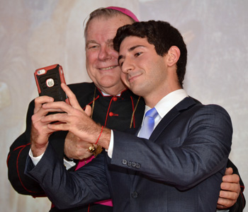 Archbishop Wenski poses for a "selfie" photo with Joshua Posner, student president at St. Thomas University.