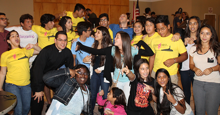 Father Bryan Garcia, parochial vicar, joins the teens and young adults of St. Andrew for Youth 4 Christ kick-off night.