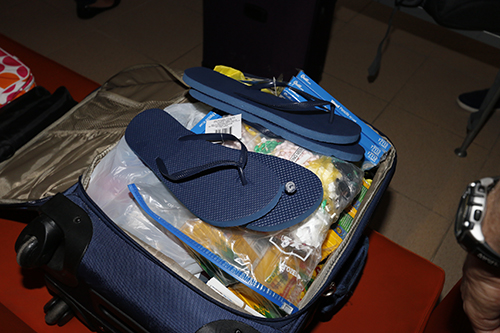 Flip flops, rosaries, medicines and pencils and paper were among the items Andy Gomez brought to donate to Father Gilbert Walker for his parishioners at La Merced parish in Havana. The flip flops and rosaries had been given to many of the Miami pilgrims for distribution to churches in Cuba, and they also were asked to bring a gallon-size bag of over the counter medicines to leave with the churches in Havana.