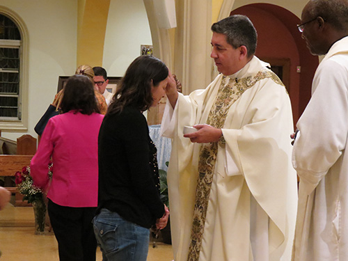 Father Luis Garcia anoints Sonia Ballesteros, a parishioner at St. Joseph Church, Miami Beach.