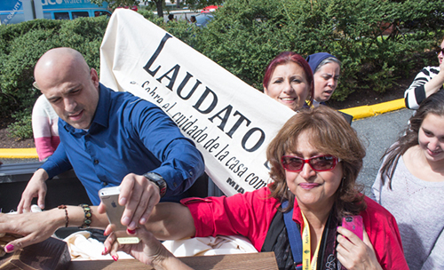 Pilgrims from Miami touch the crucifix blessed by Pope Francis during the Mass of canonization he celebrated at the Basilica of the Immaculate Conception.