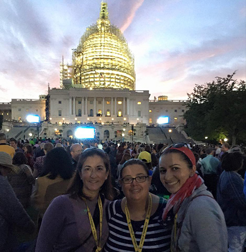 O captain, my captain: Teresa Gonzalez (left) led the group of 46 Archdiocese of Miami pilgrims throughout the journey to Washington, D.C. for the papal visit. Monica Lauzurique (center) also helped make the experience memorable and humorous, especially with innovations that kept the group together (group photo ops, and the rolled up poster used as a guide prop in front and behind of our group).