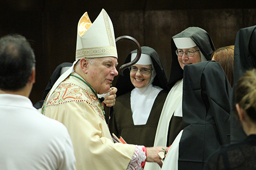 After celebrating Mass, Archbishop Thomas Wenski stops to greet Carmelites of the Most Sacred Heart of Los Angeles who staff St. Theresa School in Coral Gables and Archbishop Coleman Carroll High School in Miami.