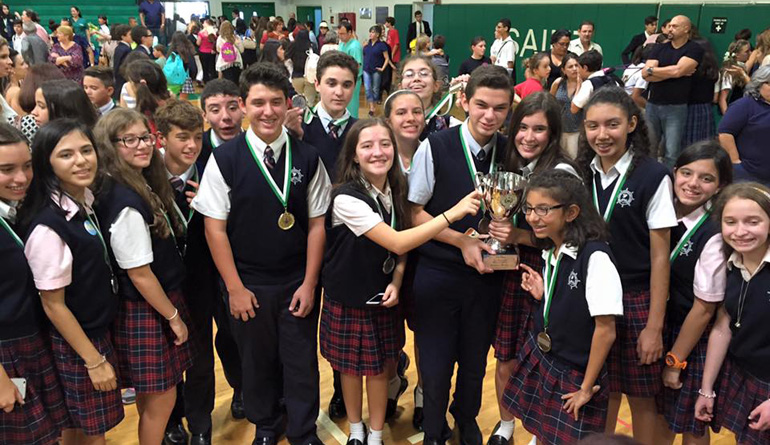 With medals around their necks and a trophy to hoist, St. Brendan School students celebrate their first place win at the Academic Olympics hosted by St. Brendan High School Oct. 2.