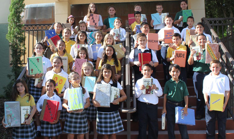 St. Kevin School fifth graders carry different books from the Bible. 
The students celebrated the Word of God at a special Mass where their personal Bibles were blessed.