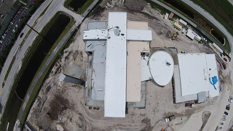 Esta imagen, tomada por un avión no tripulado, muestra los edificios de Nuestra Señora de Guadalupe: la iglesia en forma de cruz, la capilla en forma de matriz y el centro parroquial. La iglesia es visible desde el Turnpike de la Florida y desde la ruta de vuelo de los aviones que aterrizan en el Aeropuerto Internacional de Miami.