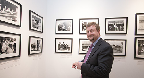Rev. Jonathan Roach, interim dean of St. Thomas University's library, stands amid the display of "La Virgen de la Caridad: Images from the Diaspora" that is part of the "Latino Americans: 500 Years of History" exhibit at St. Thomas University.