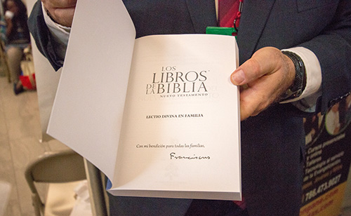 Ricardo Grzona, president and executive director of the Ramon Pane Foundation, shows the Lectio Divina for Families book that was autographed by Pope Francis.