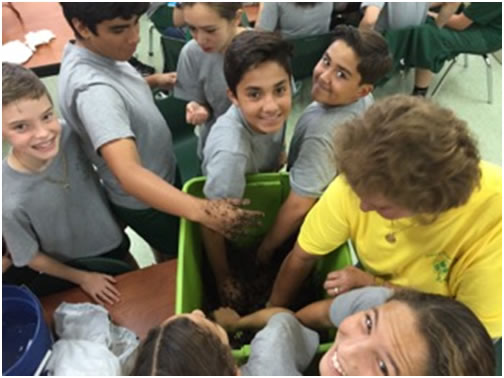 Middle schoolers from St. Kevin School get their hands really dirty in preparing the soil mix for their space garden with the aid of school Principal Mayra Constantino (right, in yellow). St. Kevin School accepted the NASA Fairchild Challenge called Citizen Science: Growing Beyond Earth.