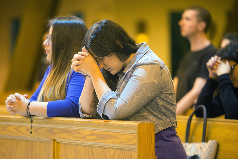 Krizia Kracker from St. David Church prays during Mass.