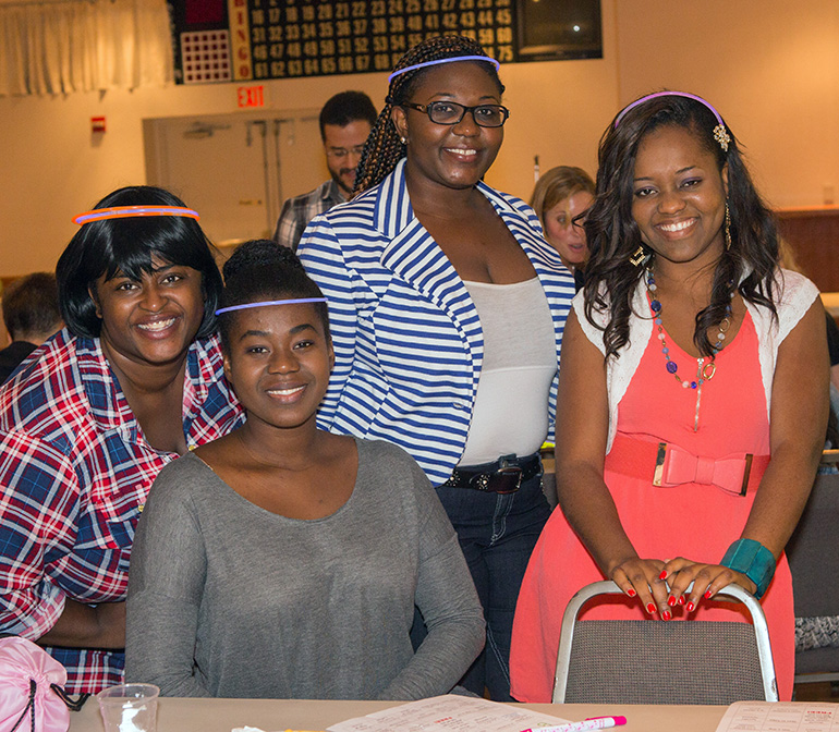 Rose Dulcio, Fanie Jocelyn, Gendia Fleurinord and Fatima Georges, from St. Clement Church, "light up the night" wearing glow sticks on their heads as they join other young adults for fellowship in St. David's parish hall.