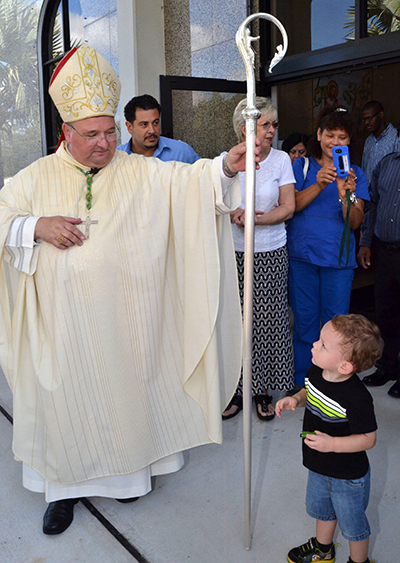 After Mass, Bishop Peter Baldacchino offers to let a little boy hold his crozier. The boy didn’t accept.