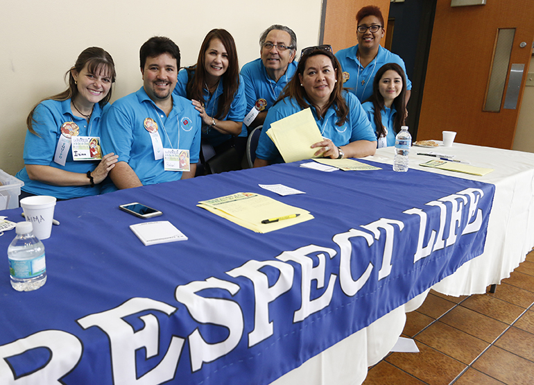 Hispanic Respect Life volunteers from parishes throughout the archdiocese welcome attendees to the Congreso Hispano Respeto a la Vida at Immaculate Conception Church in Hialeah Nov. 7.