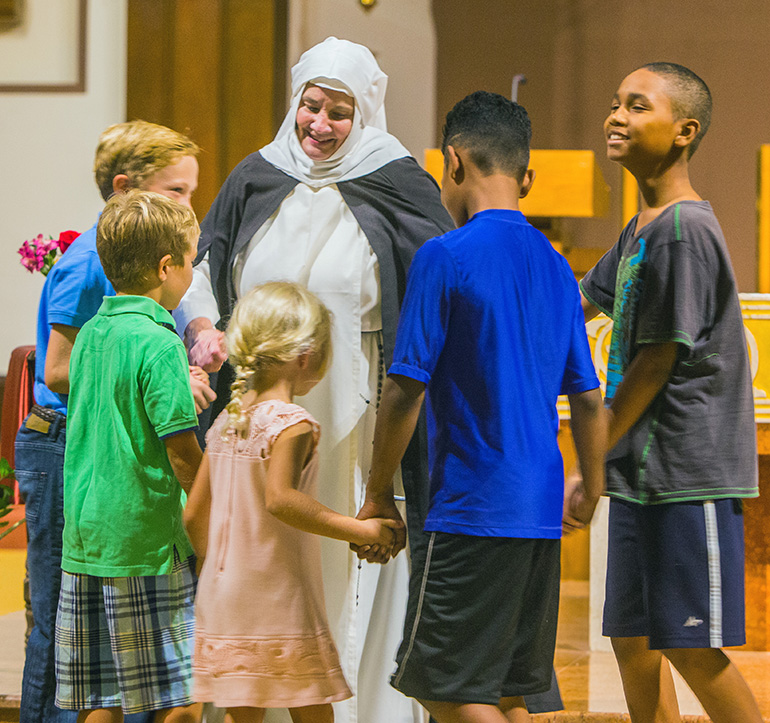 Dominican Sister Nancy Murray, portraying St. Catherine of Siena, dances the Tarantella with children from the audience.