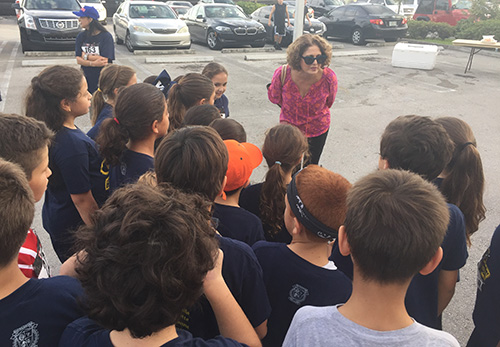 Berta Cabrera, executive director of the St. John Bosco Clinic and SSJ Health Foundation, thanks Blessed Trinity third graders for their help before the start of the Turkey Trot.