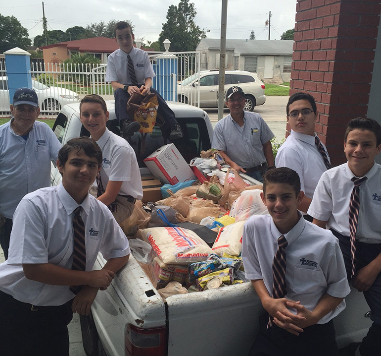Immaculate Conception eighth graders pose with one of the truckloads of food which students collected and donated to the needy. Immaculate Conception Church and School in Hialeah provided 80 families with a full Thanksgiving meal including turkey and "all the fixings."