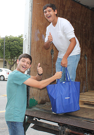 St. Kevin eighth graders Gabriel Paz and Anthony Alonso help load the food delivery truck.