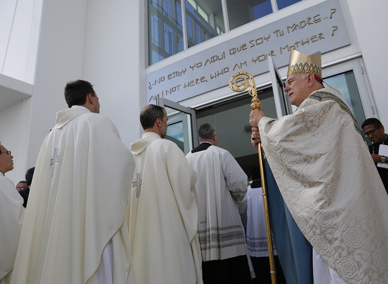 Archbishop Thomas Wenski watches as priests process into Our Lady of Guadalupe Church for the dedication Mass.