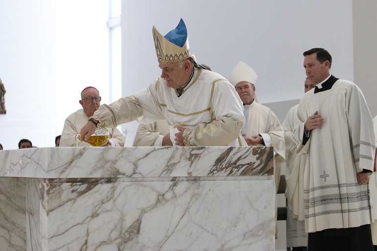 El Arzobispo Thomas Wenski vierte el aceite del crisma sobre el altar, durante el rito de la unción.