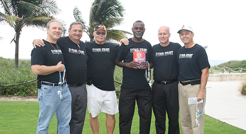 Members of the St. Paul Street Evangelization ministry gather for a photo in front of the ocean where they minister to pedestrian traffic every other Sunday from 10 a.m. to 1 p.m. From left: David Babbin, Joseph Little, Bill Amos, Josue Dumercy, Julius Hurst, and Jeff Chorba.