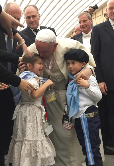 As Pope Francis exited the Paul VI Audience Hall, the two youngest members of the St. Bonaventure delegation, dressed in traditional Argentine costumes, got their own moment with the pope, who paused to kiss and bless them.  They are 4-year-old Victoria Vivot and Jonathan Echazabal.