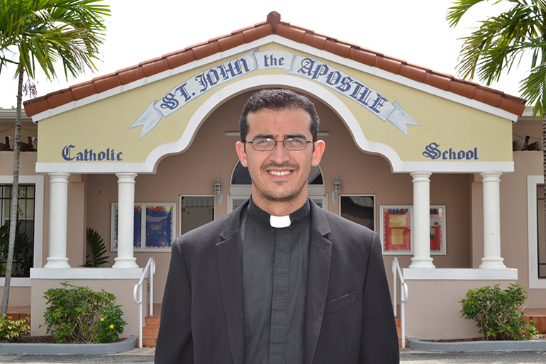 Father Ivan Rodriguez in front of St. John the Apostle School in Hialeah.
