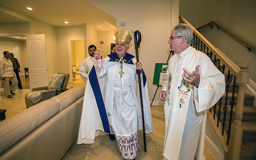 Father Michael Greer, Assumption's pastor, guides Archbishop Thomas Wenski through the new rectory and office building during the blessing ceremony.