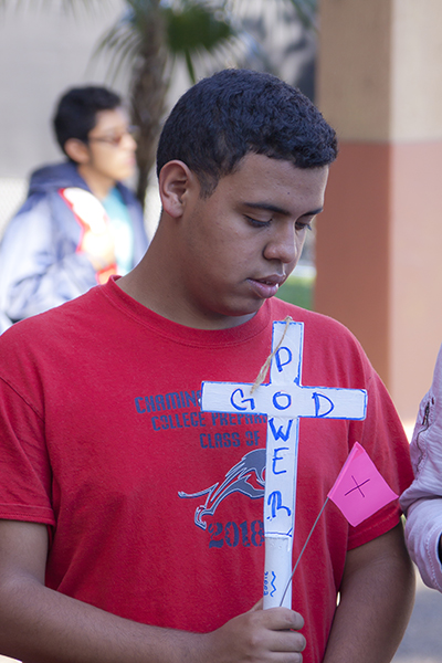 Francisco Rosa, from the Life Teen group at St. Stephen Church in Miramar, carries a cross during the 16th annual Walk for Life at Archbishop McCarthy High School.