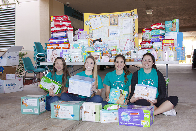 From left, Alyssa Villalba, Gabriella Rodriguez, Antonella Banegas and Gabrielle Martinez, members of the Respect Life Club at Archbishop McCarthy High School, hold baby supplies donated at the school's 16th annual Walk for Life in Southwest Ranches.