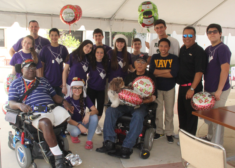 Students from the Purple Heart Club at Immaculata-La Salle High School gather with military veterans for a photo during a Christmas party at the VA Hospital in Miami. The Purple Heart Club supports active and former U.S. military servicemen and women.
