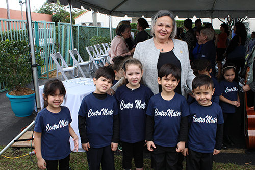 Centro Mater West teacher Olga Roque poses with some of her students who sang in the children's choir during the 20th anniversary celebration.