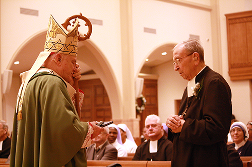 El Hno. Rafael Martin, de 91 años, que cumple 75 años con los Hermanos Maristas, recibe su regalo de reconocimiento del Arzobispo Thomas Wenski.