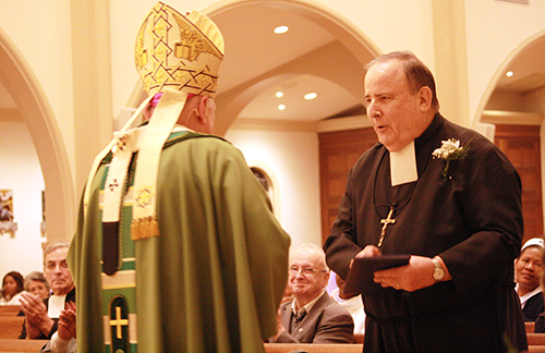 El Hno. Vicente Moriarty, que cumple 60 años como Hermano Marista, recibe su regalo de reconocimiento del Arzobispo Thomas Wenski.