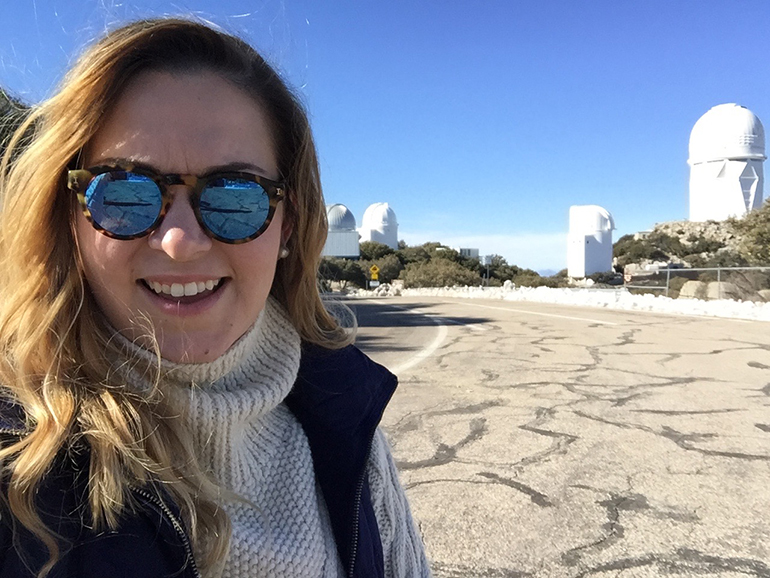 With telescopes in the background, Immaculate Conception School science teacher Bianca Acosta takes a selfie in front of the Kitt Peak National Observatory.