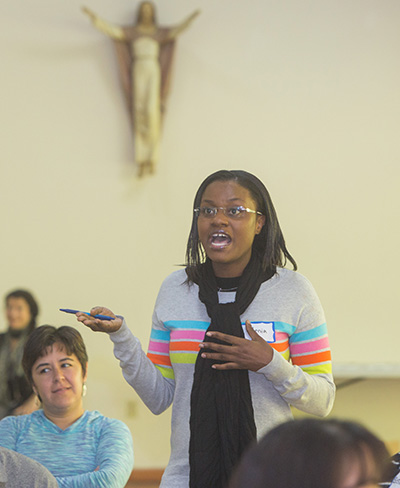 Stenia Accilieu, a youth minister from St. James Church in North Miami, asks a question during the workshop.