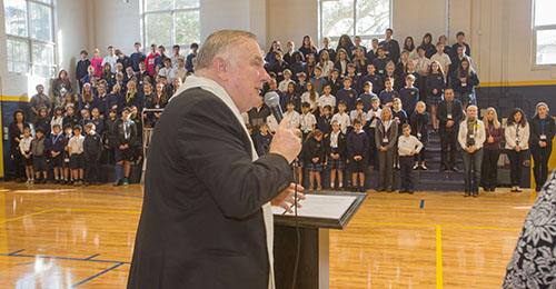 Archbishop Thomas Wenski addresses faculty, staff and students in St. Anthony School's renovated gymnasium.