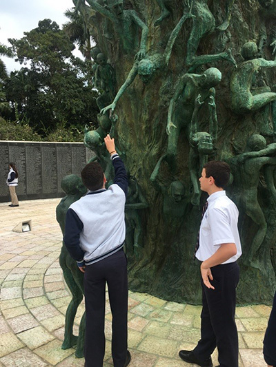 Immaculate Conception students get a close up look at the Sculpture of Love and Anguish in the Holocaust Memorial. The towering arm rises from the center to anchor the entire work. The arm bears more than 100 intertwined figures, each portraying its own testimony. It is encircled by other freestanding victims.