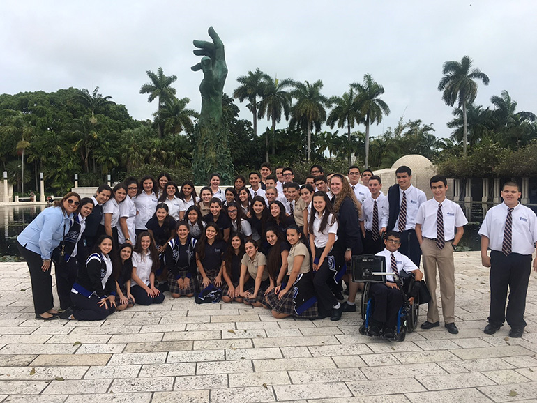 Eighth graders from Immaculate Conception School pose in the Garden of Meditation at the Holocaust Memorial. Rising behind them is the Sculpture of Love and Anguish that honors the victims by depicting their stories.